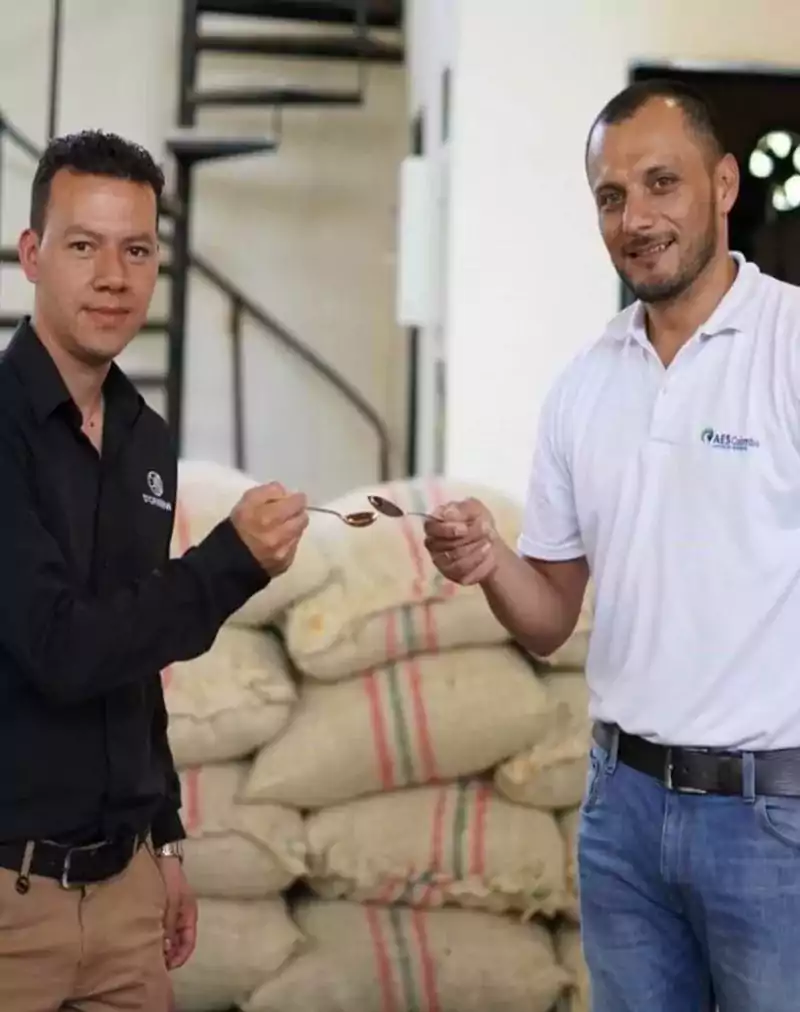 two men standing with coffee bags